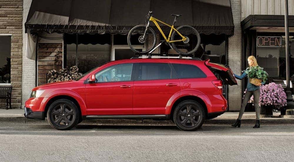 A red 2020 Dodge Journey is parked in front of a store.