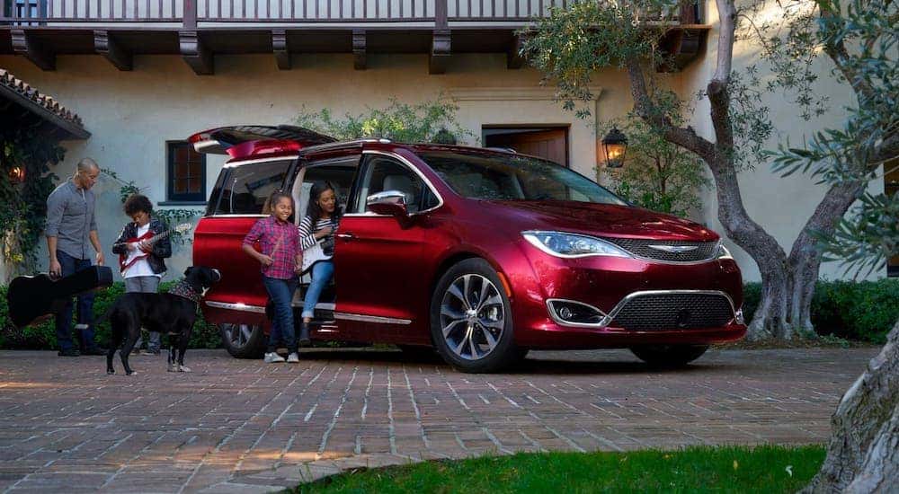 A family is about to get into a red 2017 Chrysler Pacifica.