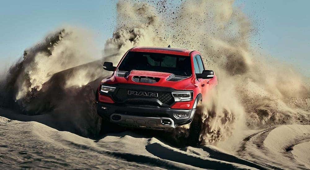 A red 2021 Ram 1500 TRX is kicking up sand while off-roading near Lexington, KY.