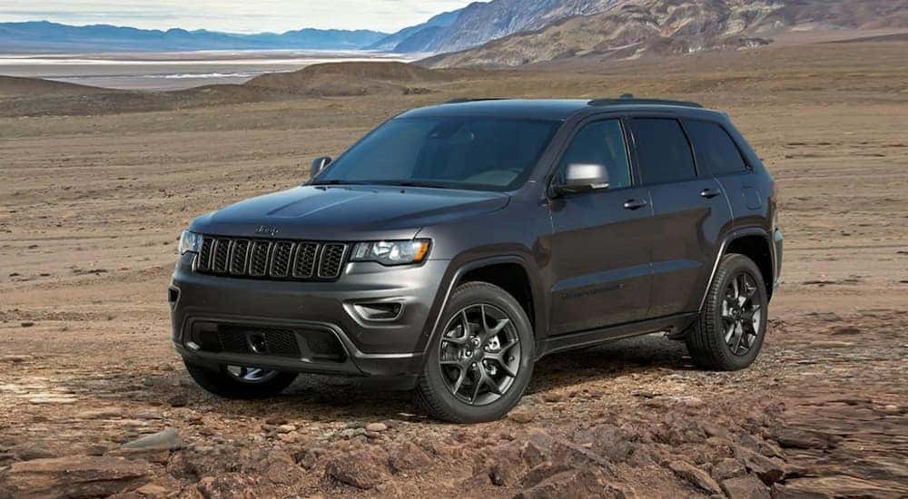 A grey 2021 Jeep Grand Cherokee is shown from the side parked in a desert.