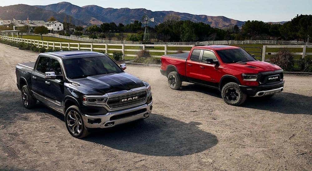A blue and red 2019 Ram 1500 are parked at a ranch after leaving a used Ram 1500 truck dealership.