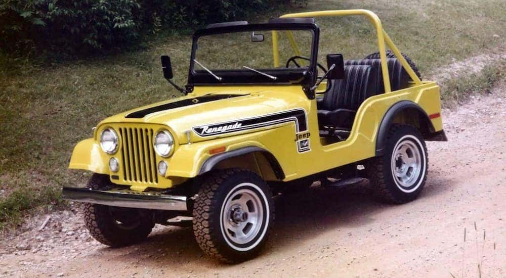 A yellow 1973 Jeep Wrangler CJ-5 is shown from the front at an angle after leaving a Jeep dealer.