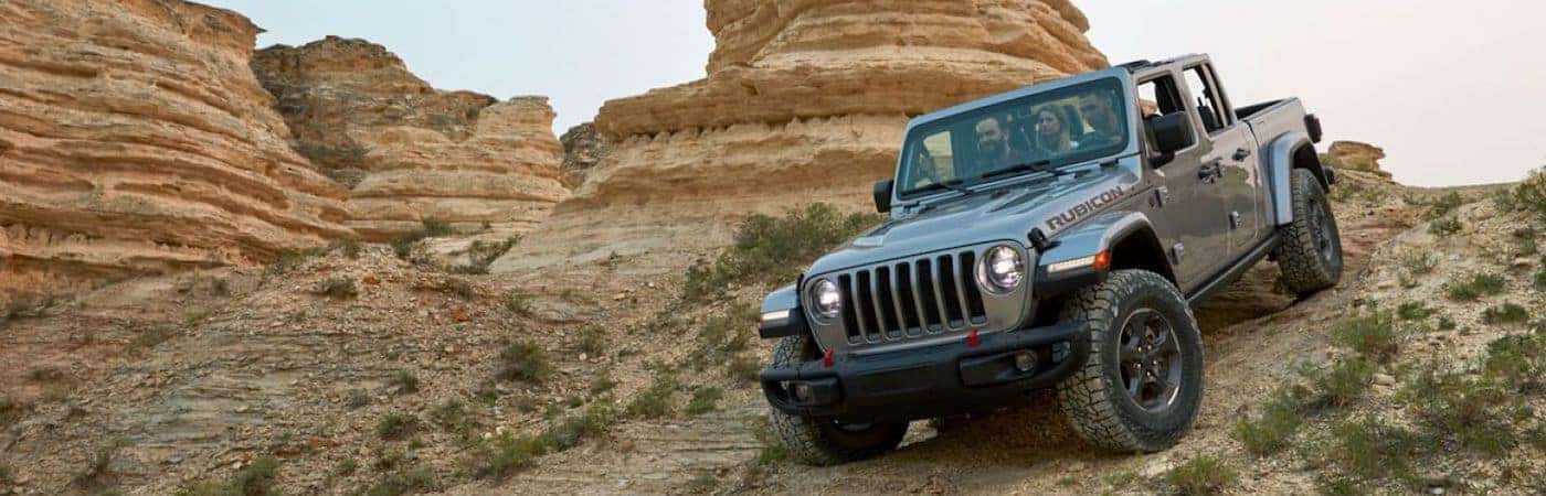 A 2020 Jeep Gladiator driving down a dirt hill