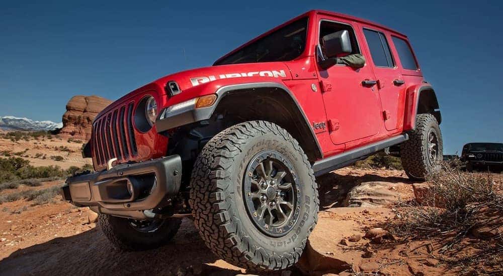 A red 2024 Jeep Wrangler Rubicon is shown from the front at an angle.