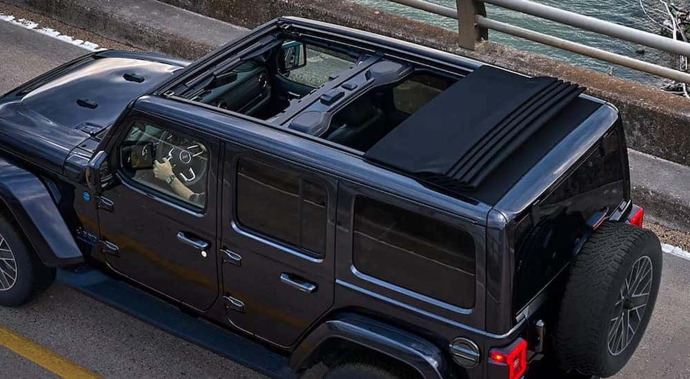The retractable hardtop of a grey 2024 Jeep Wrangler for sale near Louisville is shown from the rear at a high angle.