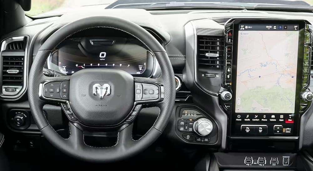 The black wheel and dashboard in the interior of a 2025 Ram 1500 Tungsten.