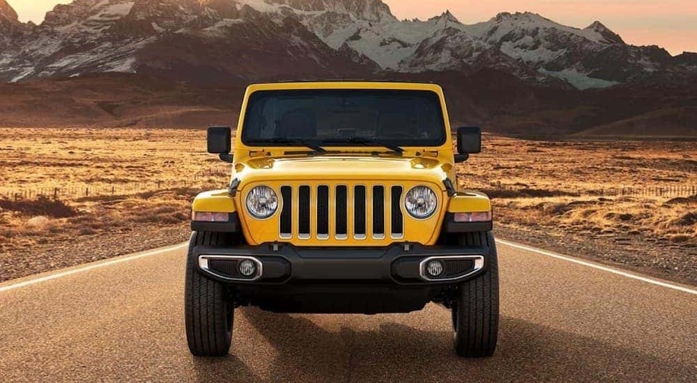 A yellow 2021 Jeep Wrangler is shown parked near a mountain.