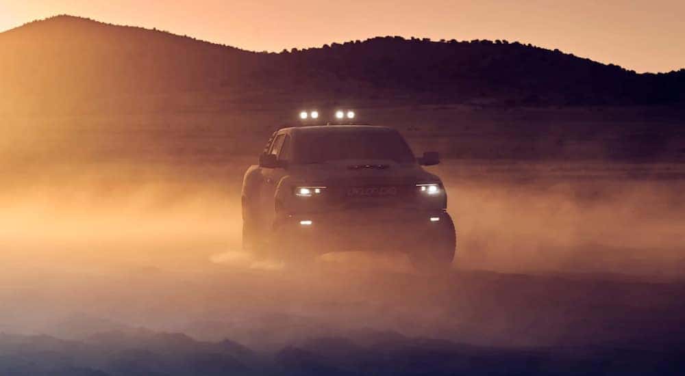 A grey 2021 Ram TRX is parked in a dusty desert after leaving a Lexington Ram TRX dealer.