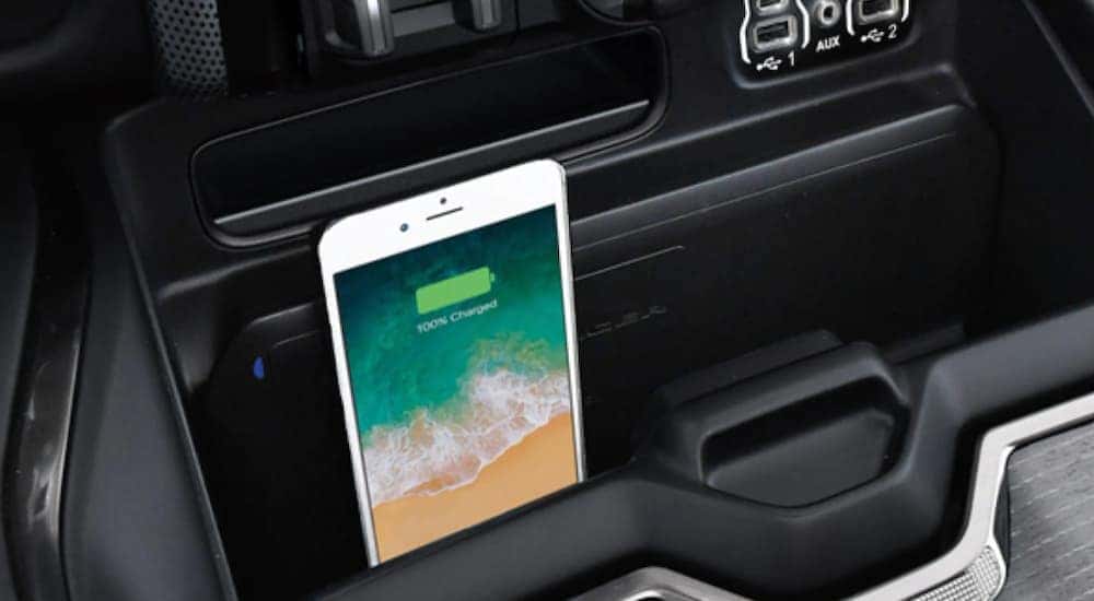 A close up shows a smartphone charging wirelessly in a 2021 Ram 1500.