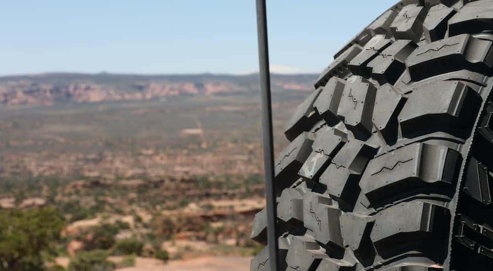 A close up shows the tread on a spare tire overlooking the Moab Desert in UT.