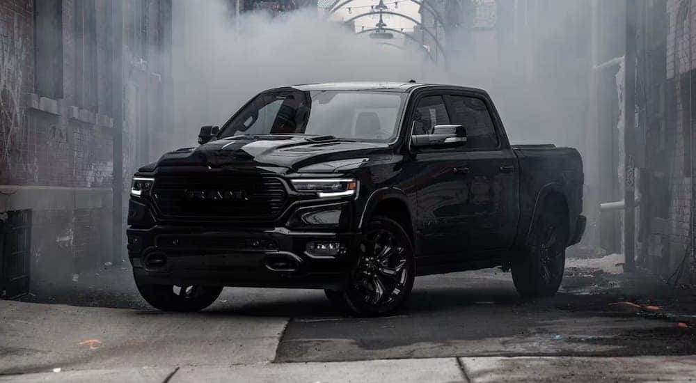 A black 2023 Ram 1500 is shown parked in a city alleyway.