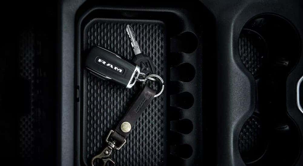 A close-up of a Ram keychain is shown in the center console in a 2024 Ram 1500 Big Horn.