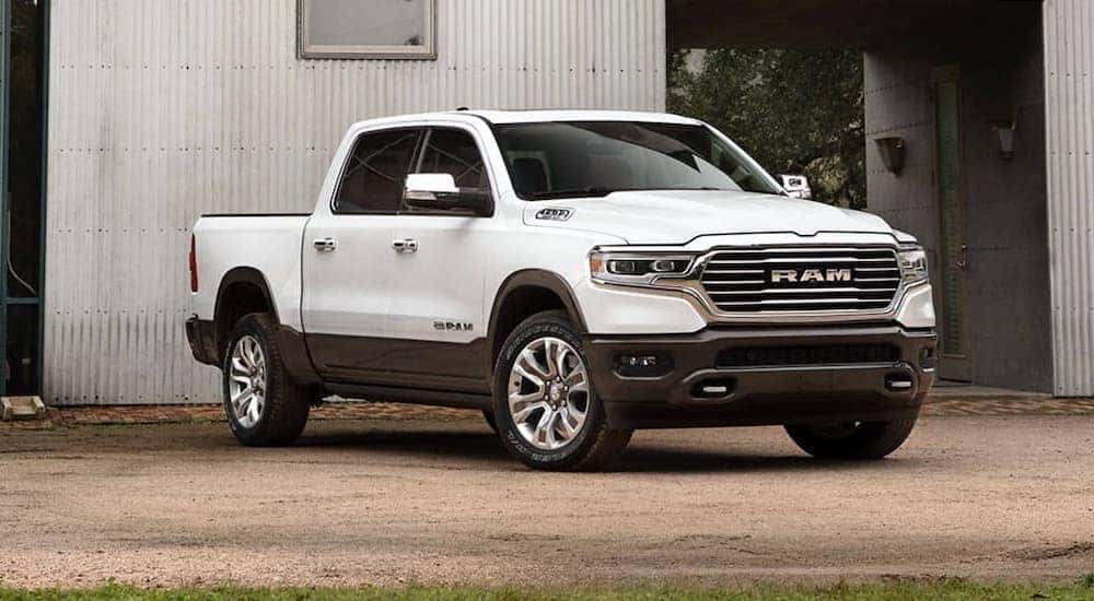 A white 2020 Ram 1500 Longhorn is shown parked outside of a metal barn.