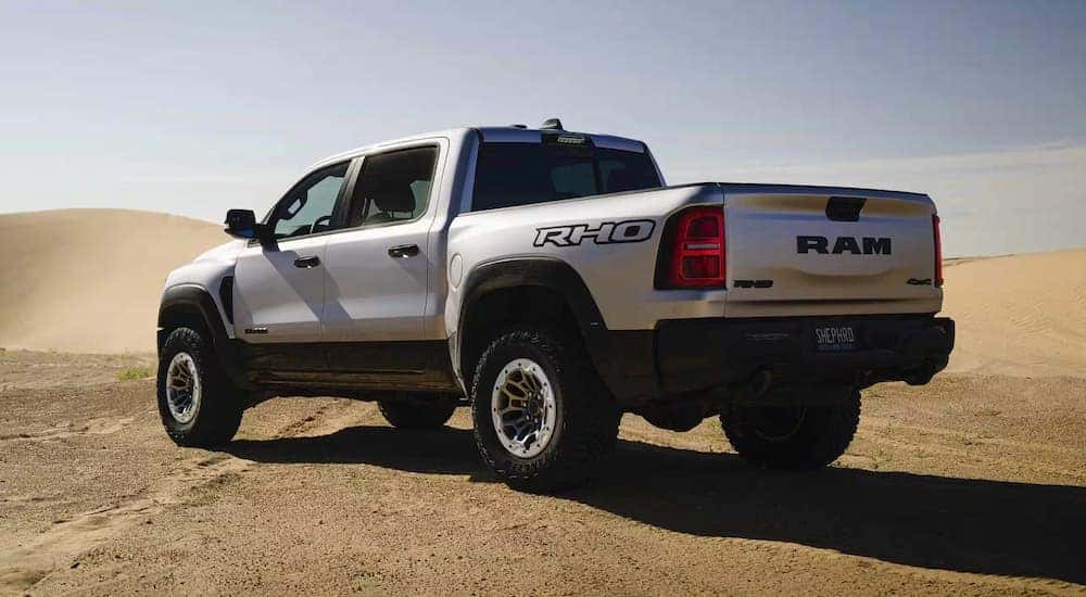 A silver 2025 Ram 1500 RHO parked in a desert.
