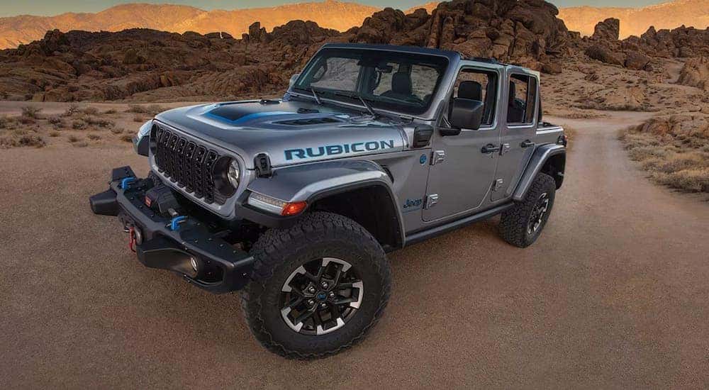 A silver 2024 Jeep Wrangler Rubicon is shown parked off-road.