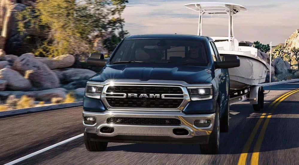 A blue 2024 Ram 1500 Big Horn is shown driving to a Ram dealer near Louisville.