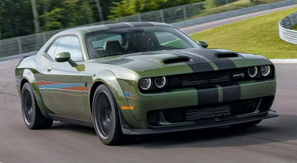A green 2020 Dodge Challenger is driving on a racetrack.