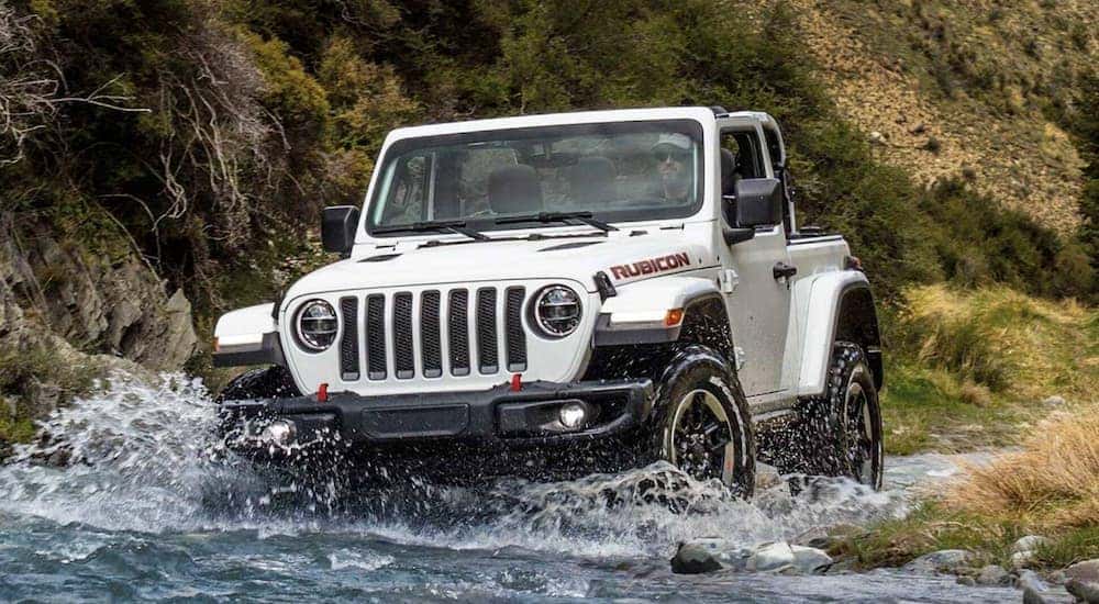 A white 2021 Jeep Wrangler Rubicon is shown driving off-road.