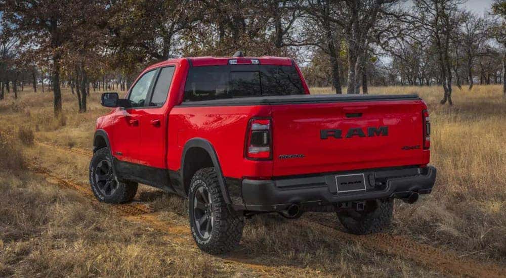 A red 2021 Ram 1500 is shown from the back driving away.
