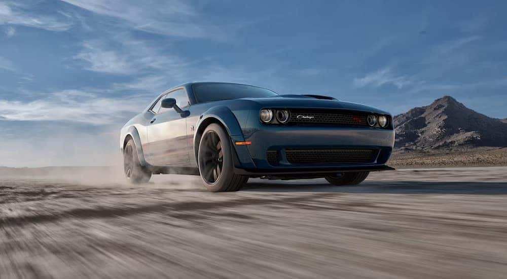 A blue 2023 Dodge Challenger Scat Pack Wide Body is shown from the front at an angle after leaving a used Dodge dealership.