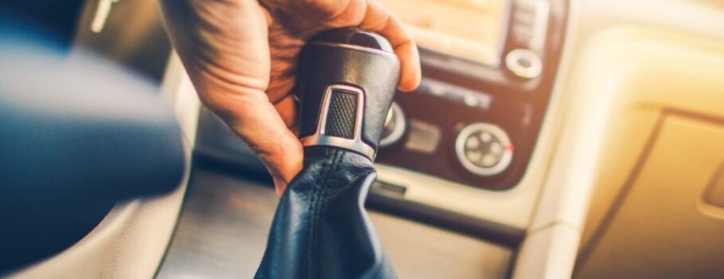 image of a hand on a car's manual transmission