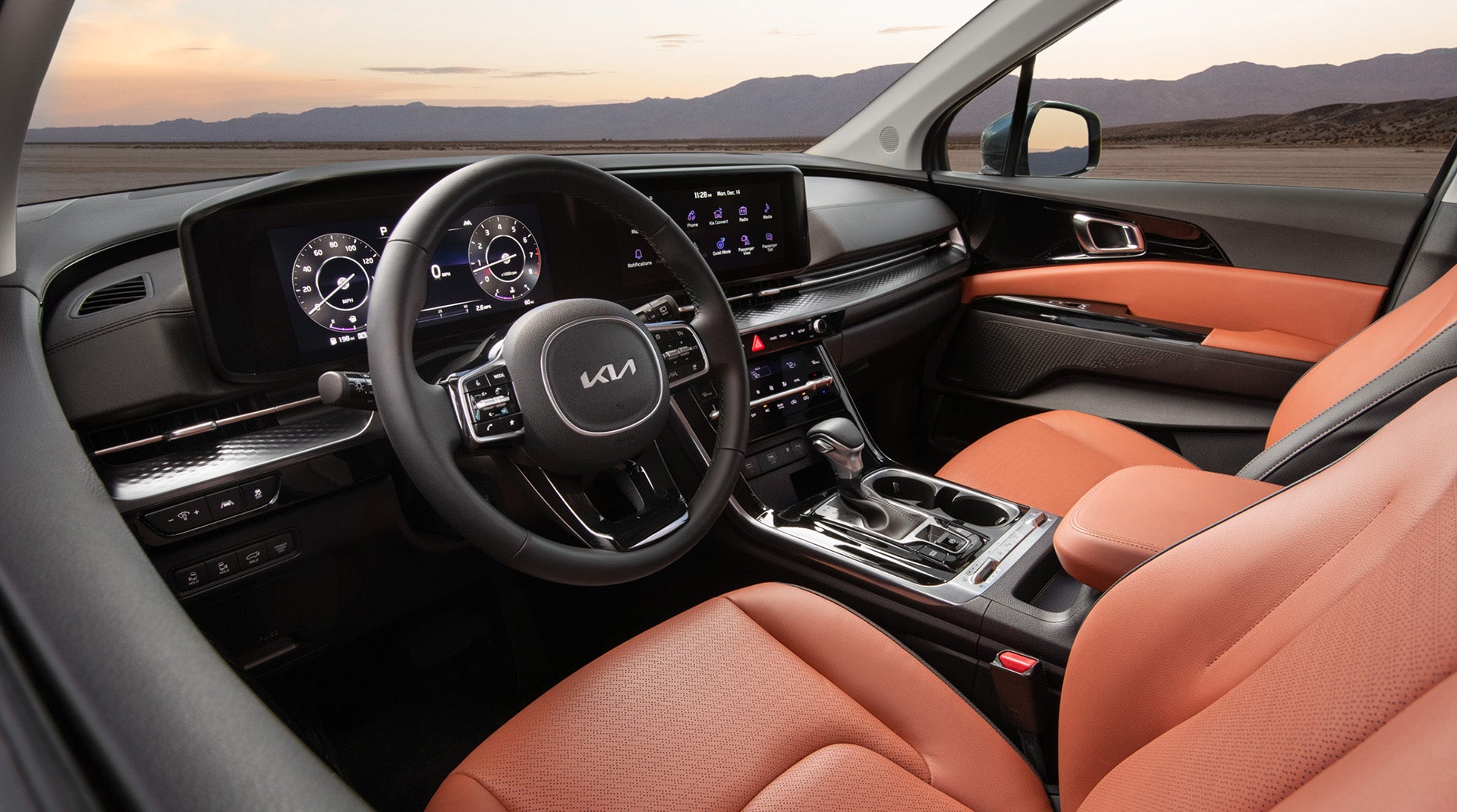 Interior of a Kia SUV with modern dashboard displays and orange leather seats
