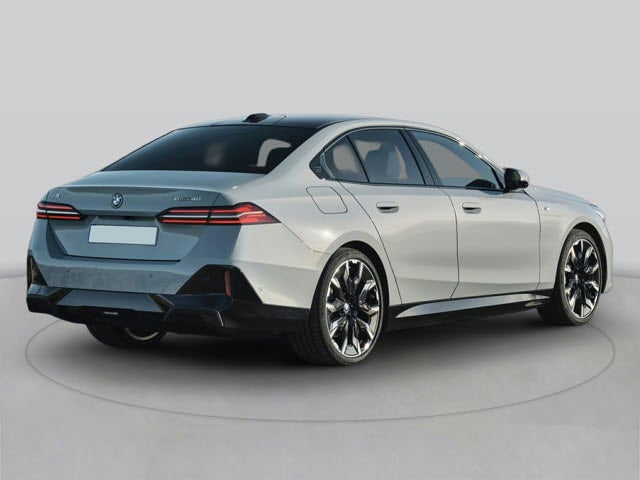 A silver 2025 BMW i5 sedan shown from the rear, featuring sleek lines and sporty wheels.