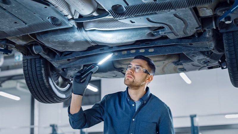 technician looking underneath a car