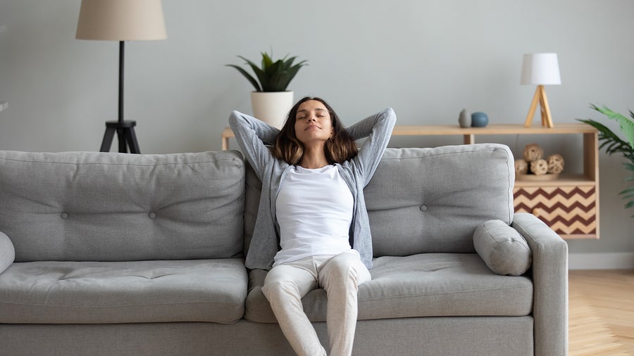 Attractive Woman Leaned On Couch Resting In Living Room
