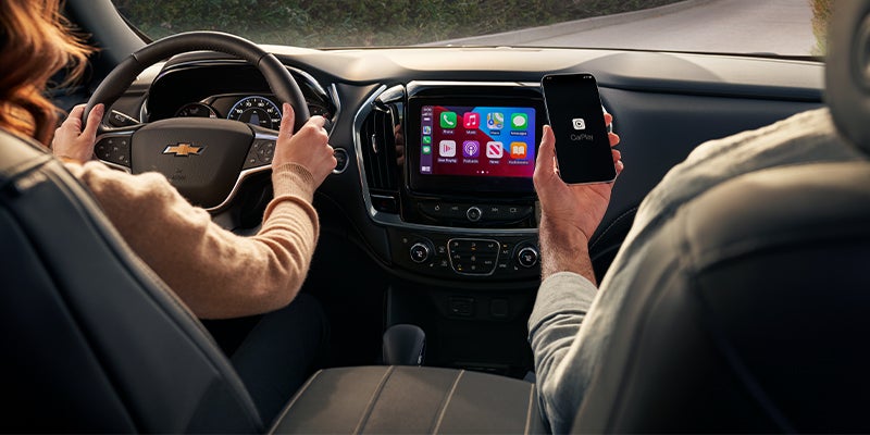 Front seats and dashboard of the 2023 Chevy Traverse with 8-inch touchscreen and leather trim