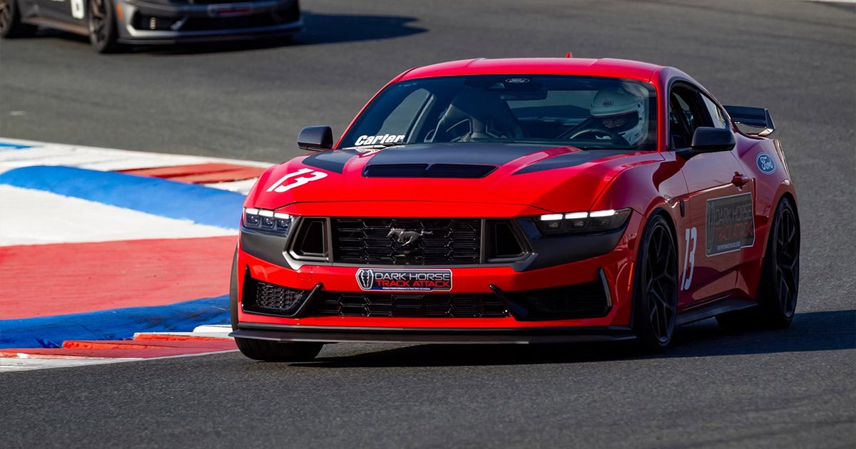 Red Ford Mustang Dark Horse racing on track with number 18, performance sports car in action