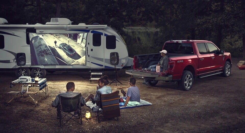 family at their campsite with their trailer and red Ford F-150