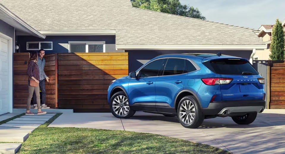 blue Ford Escape parked in front of a home in drivewar