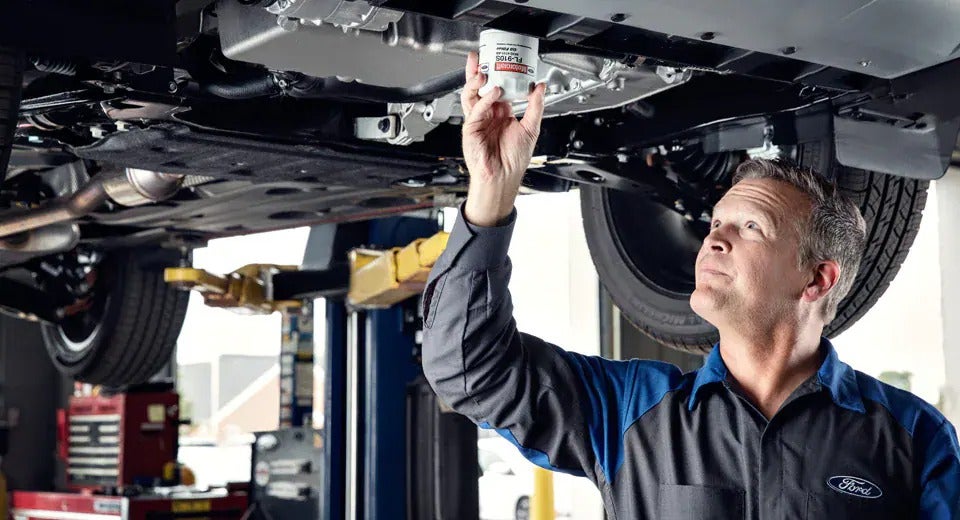 service technician changing oil on a vehicle