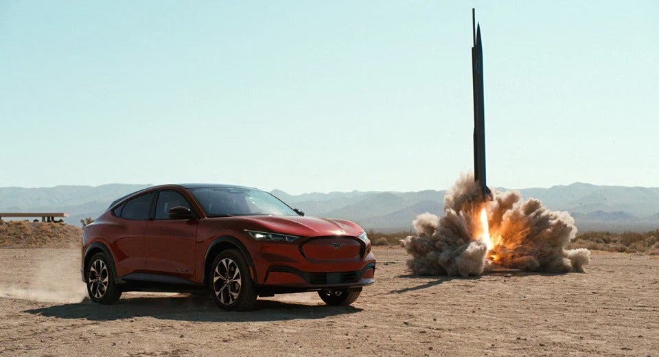 Ford Mustang Mach-E parked next to a rocket