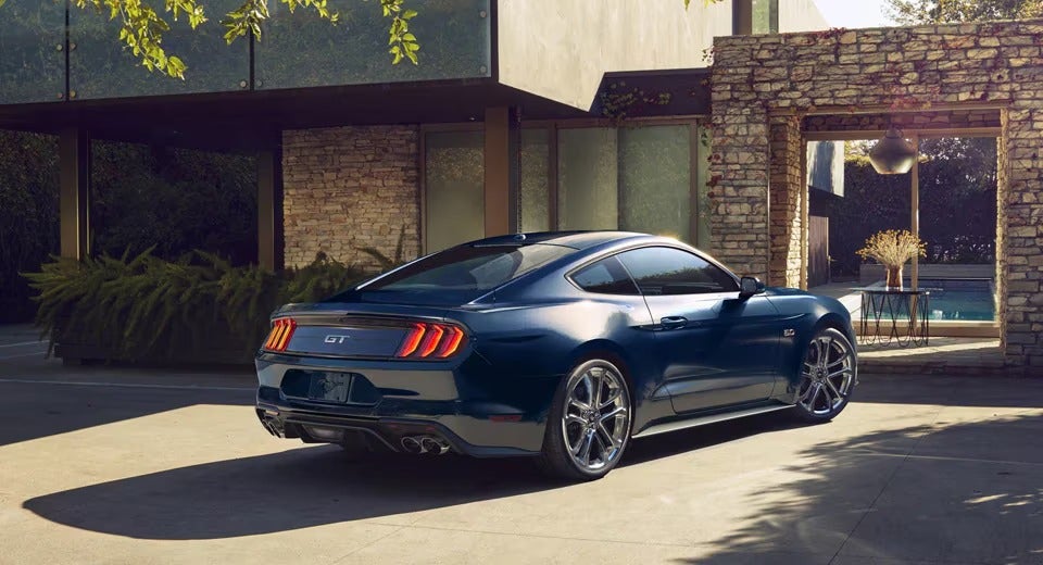 dark blue Mustang GT parked in front of a modern home