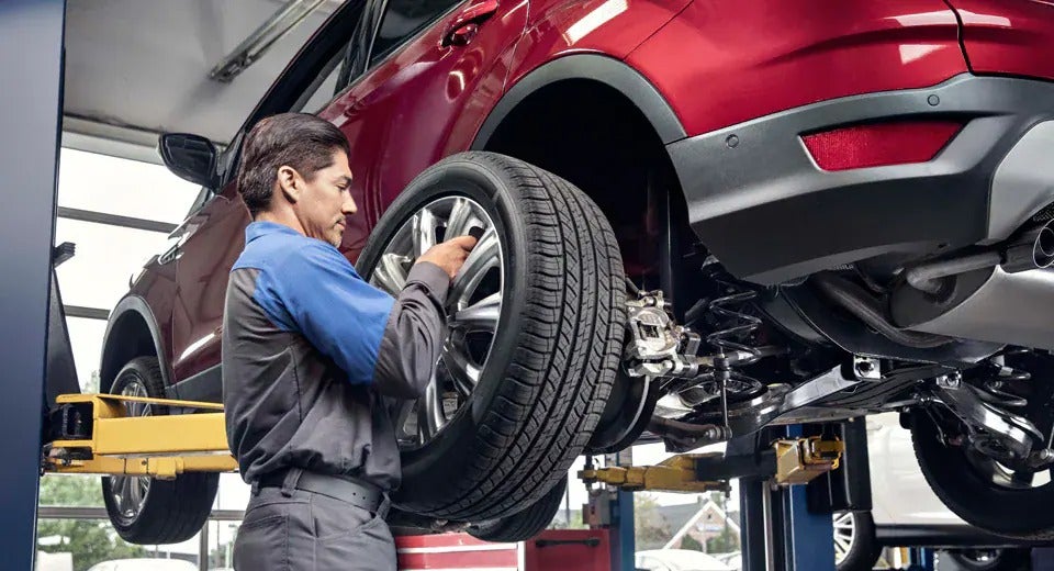 Ford technician changing a tire on a vehicle