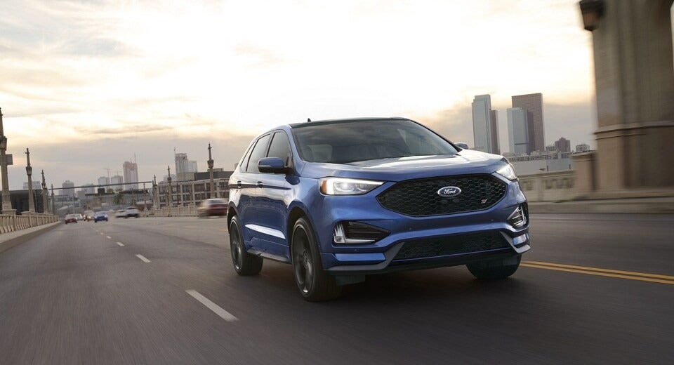 blue Ford Escape driving on a highway