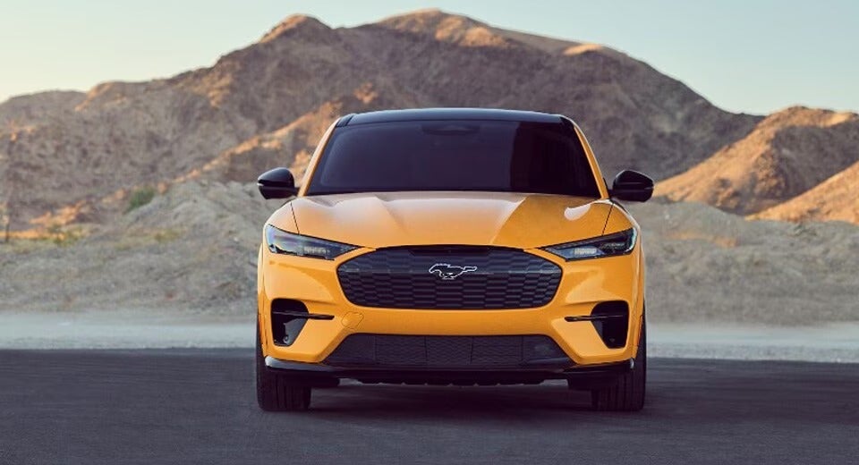 front view of a yellow Mustang-E GT parked in front of a desert