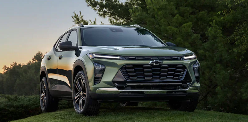 A green 2026 Chevy Trax parked on a grass hill.