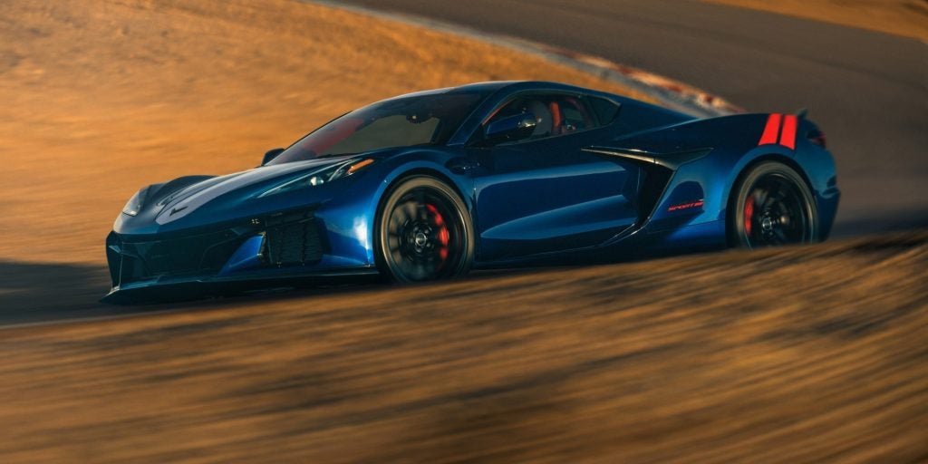 Blue Chevrolet Corvette driving on a racetrack, angled side view