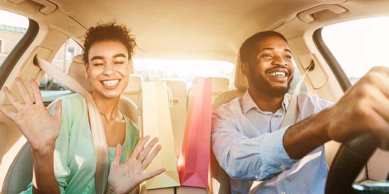 couple driving in their new used car