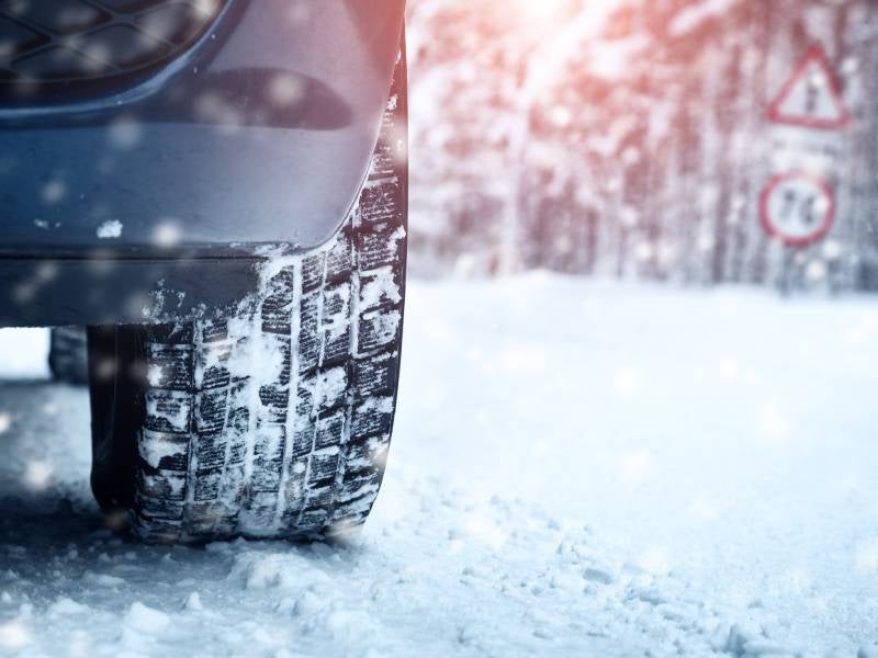 close up winter tires driving in snow
