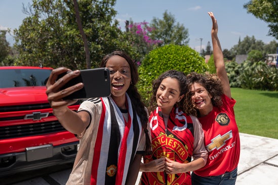 group of girls taking a selfied in front of their Chevrolet