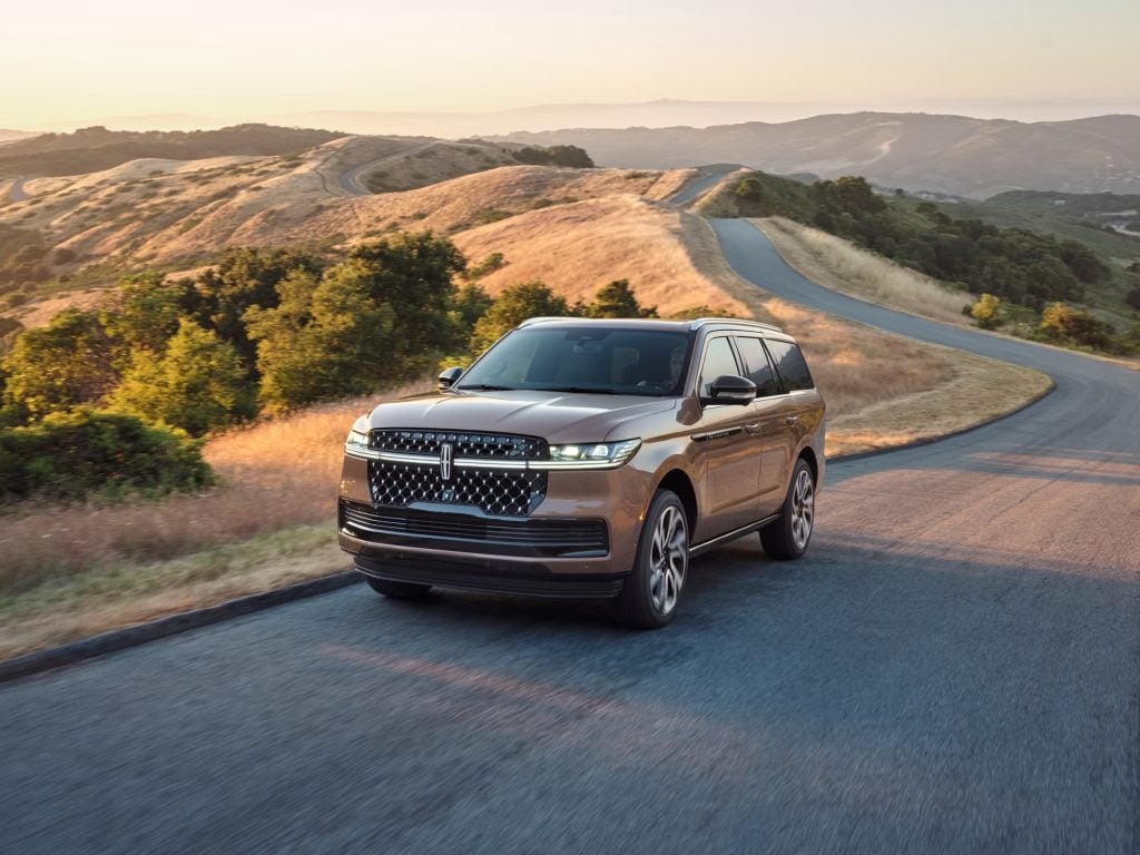 A 2026 Lincoln Navigator Black Label SUV driving on the road.