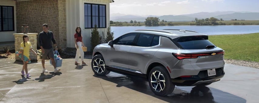 Family walking to their new chevy car in the driveway.