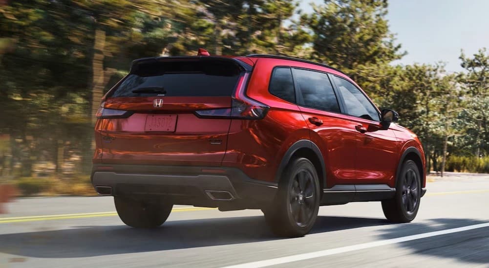 A red 2026 Honda CR-V driving to a Honda dealer near Bessemer.