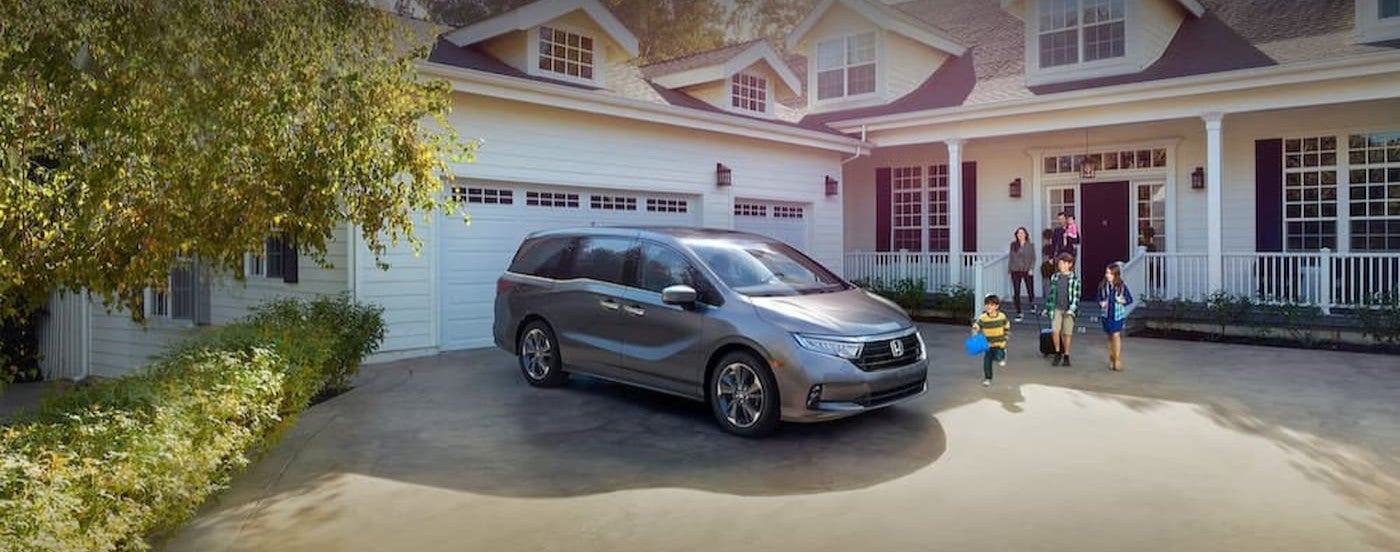 A silver 2025 Honda Odyssey parked on a driveway.
