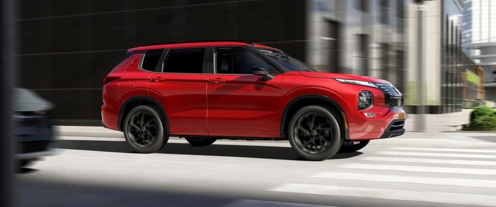 Red Nissan SUV in motion on a city street