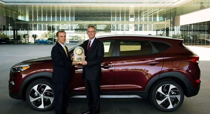 two men holding their JD Power award